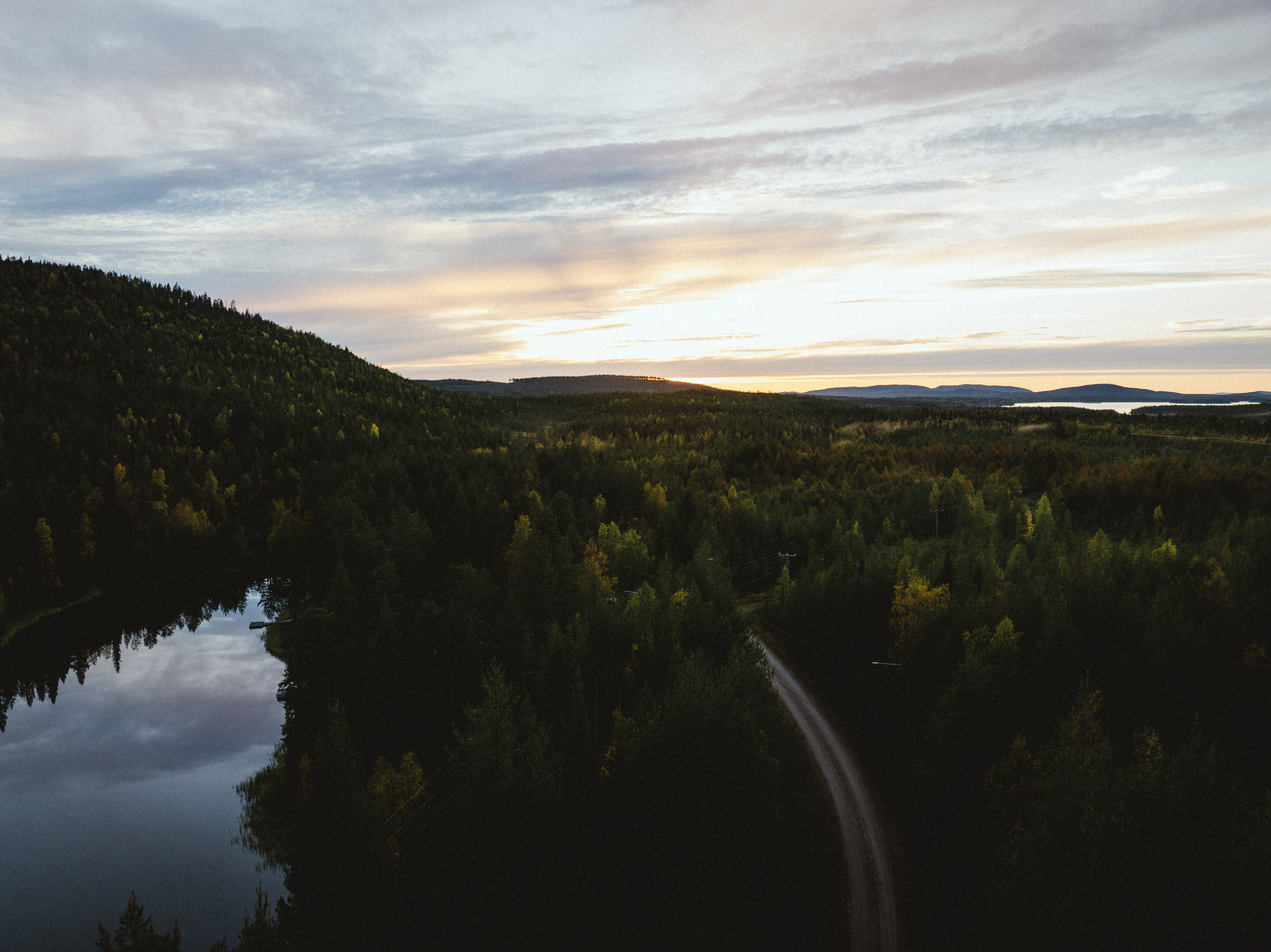 Kesäinen ilmakuva metsän, järven ja tien yli Suomun alueella
